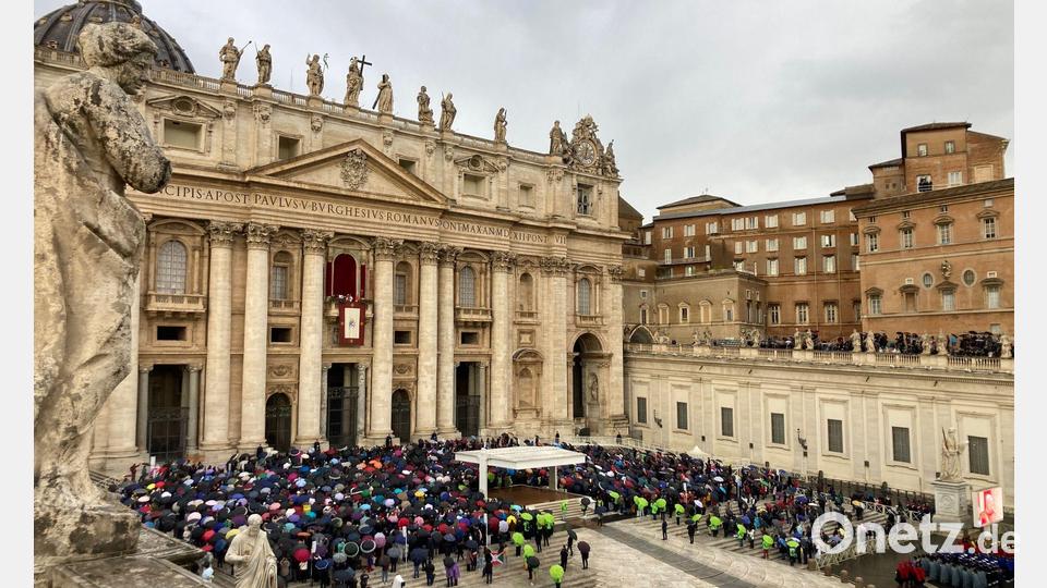 Mit Regencapes und unter Regenschirmen verfolgten die Gläubingen die Ansprache des Papstes. Bild: Sabine Dobel/dpa