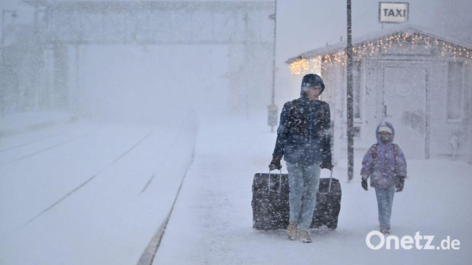 Menschen gehen bei starkem Schneefall am Bahnhof in der Stadt Åre in Schweden, nachdem der Zugverkehr eingestellt wurde. Bild: Pontus Lundahl/TT News Agency/AP/dpa