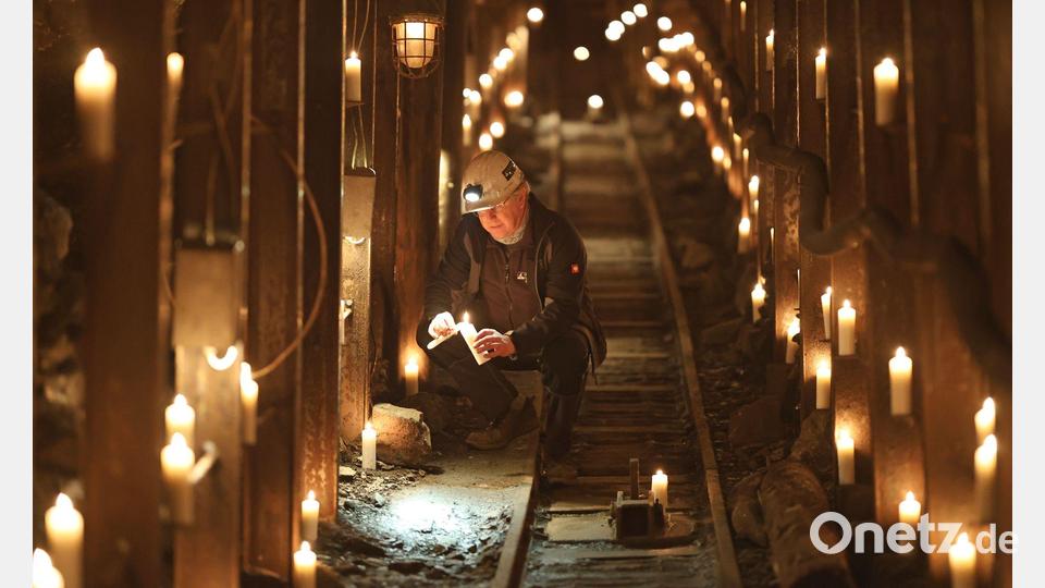 Uwe Reisner vom Förderverein Rabensteiner Stollen zündet im Stollen Kerzen an. Bild: Matthias Bein/dpa