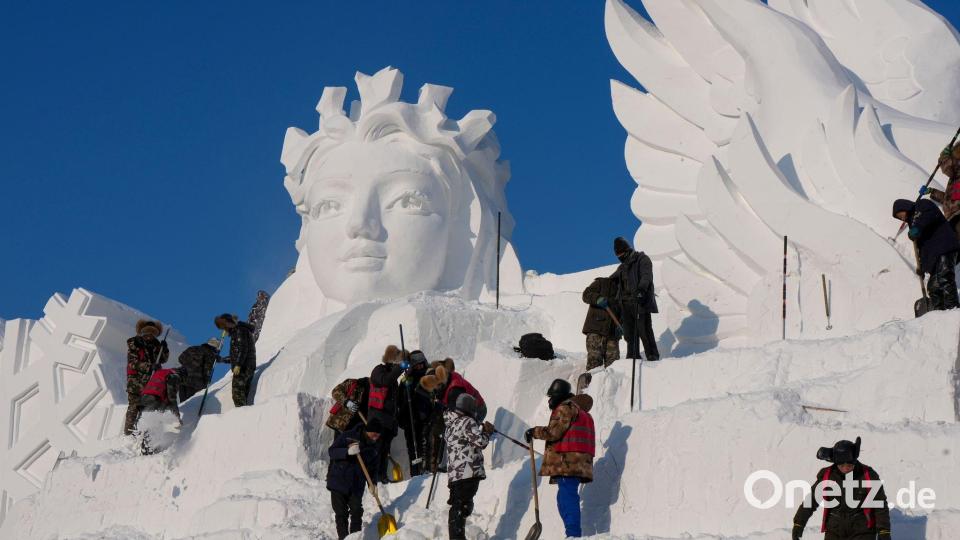Künstler arbeiten an einer Schneeskulptur. Bild: Wang Song/XinHua/dpa