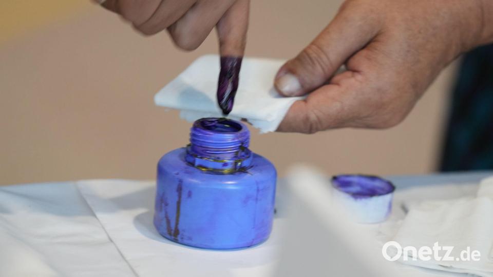 Ein Wähler taucht seinen Finger in ein Tintenfass. Bild: Thein Zaw/AP/dpa