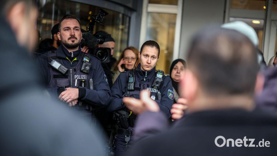 Polizeibeamte sprechen mit möglicherweise betroffenen Kunden der Sparkassenfiliale in Buer. Bild: Christoph Reichwein/dpa