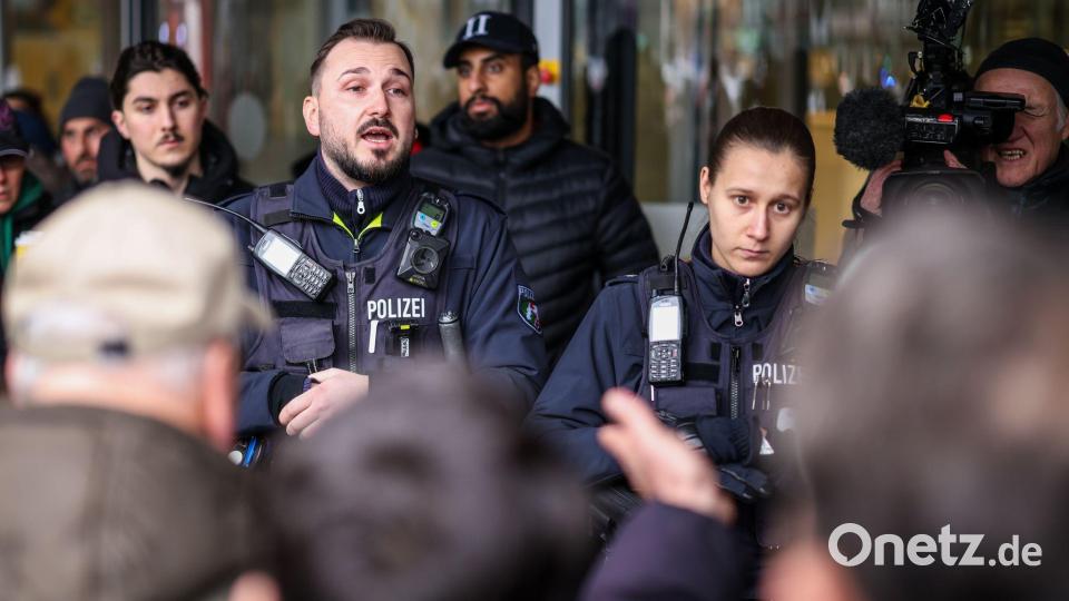 Polizeibeamte sprechen mit möglicherweise betroffenen Kunden der Sparkassenfiliale in Buer. Bild: Christoph Reichwein/dpa