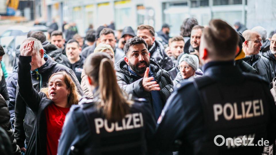 Aufgebrachte Kunden diskutieren mit der Polizei nach dem Einbruch in die Sparkasse Buer. Bild: Christoph Reichwein/dpa