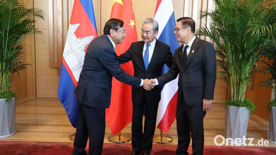 Der kambodschanische Außenminister Prak Sokhonn (l) schüttelt die Hand seines thailändischen Amtskollegen Sihasak Phuangketkeow (r) vor dem chinesischen Amtskollegen Wang Yi. Bild: Uncredited/Agence Kampuchea Press/AP/dpa