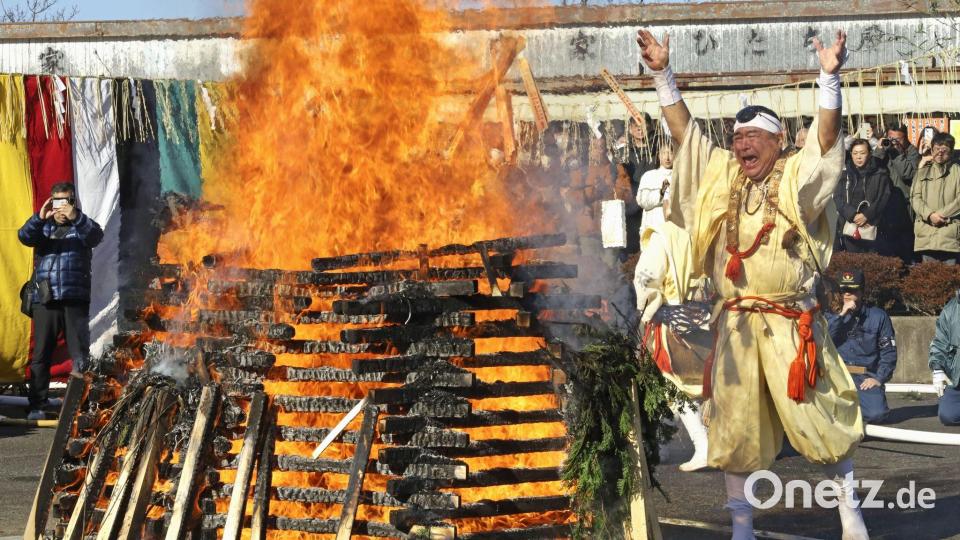 Ein Mönch wirft Glücksbringer und Amulette als Dank in ein Feuer. Bild: Uncredited/kyodo/dpa