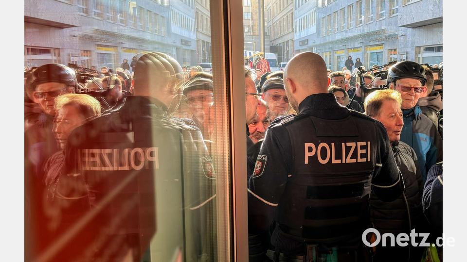 Polizisten sichern den Eingang der Sparkassenfiliale in Gelsenkirchen, vor der viele besorgte Kunde stehen und Informationen nach dem Einbruch in den Tresorraum verlangen. Bild: Christoph Reichwein/dpa