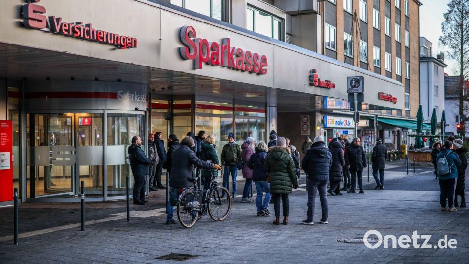 Nach einem Einbruch in den Tresorraum einer Bankfiliale in Gelsenkirchen warten Menschen vor dem Eingang auf Informationen. Bild: Christoph Reichwein/dpa