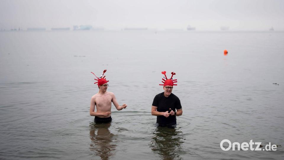 Menschen waten im Wasser während des olar Bear Swim in Vancouver. Bild: ETHAN CAIRNS/The Canadian Press/AP/dpa