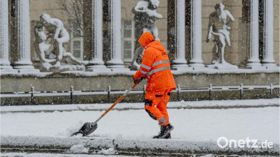 Ein Mitarbeiter der Stadtreinigung Potsdam befreit eine Tram-Haltestelle vom Schnee. Bild: Georg Moritz/dpa