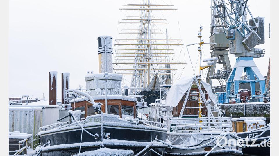 Schneebedeckte Schiffe liegen im Museumshafen in Hamburg. Bild: Markus Scholz/dpa