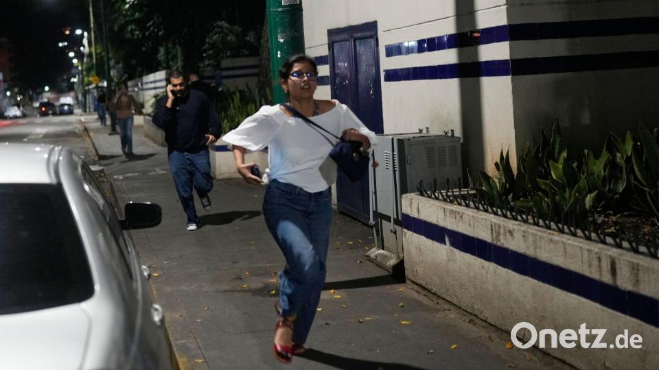 Fußgänger rennen, nachdem Explosionen zu hören waren. Bild: Matias Delacroix/AP/dpa