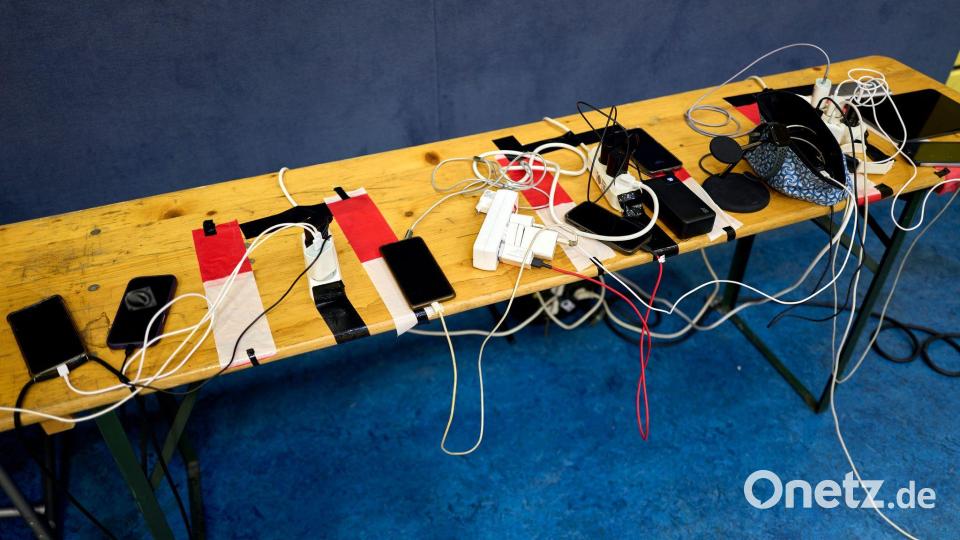 Viele Menschen nutzen die Möglichkeit, ihre Handys an Anlaufstellen aufzuladen. Bild: Michael Ukas/dpa