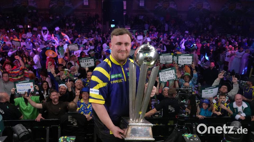 Littler präsentiert zum zweiten Mal die WM-Trophäe. Bild: Dave Shopland/AP/dpa