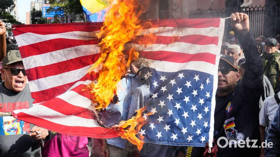 Anhänger der Regierung verbrennen eine US-Flagge in Caracas, nachdem US-Präsident Trump bekannt gegeben hatte, dass die US-Streitkräfte den venezolanischen Präsidenten Maduro und seine Frau gefangen genommen haben. Bild: Ariana Cubillos/AP/dpa