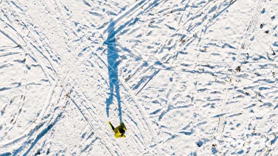 Ein Mann joggt am Kronsberg und wirft einen langen Schatten (Luftaufnahme mit Drohne). Bild: Julian Stratenschulte/dpa