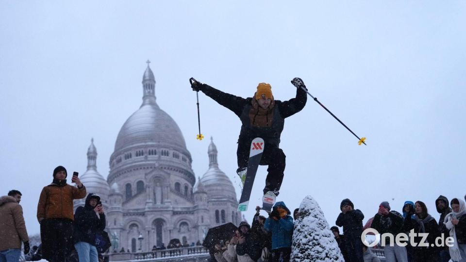 Ein Mann springt mit seinen Skiern den Hügel bei der Basilika Sacre-Coeur im französischen Paris hinunter. Bild: Aurelien Morissard/AP/dpa