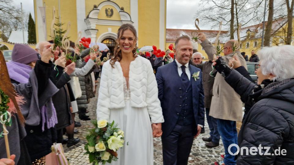 Hochgehaltene Notenschlüssel, bunte Luftballons und viele beste Wünsche begleiten das Ehepaar Lehnerer nach der Trauung. Bild: mab