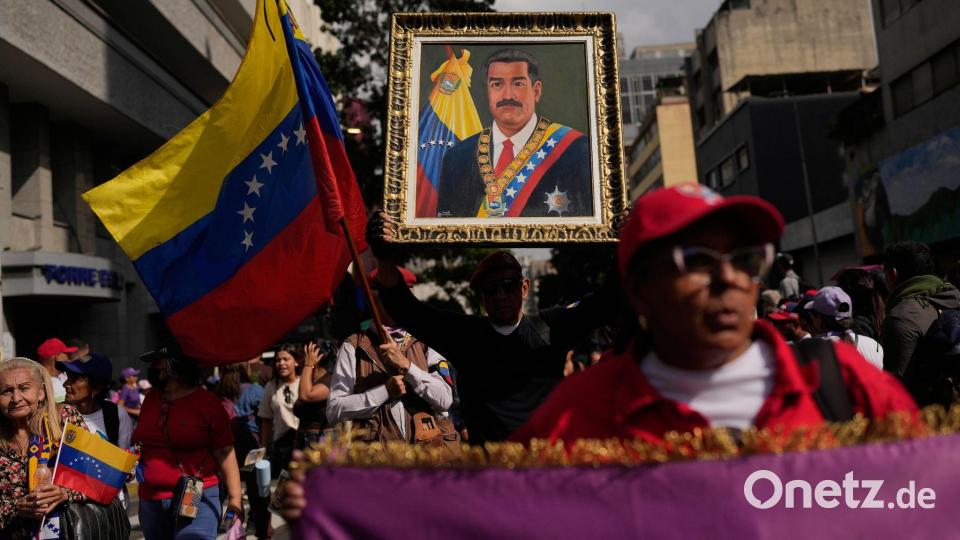 Ein Anhänger der Regierung hält ein Bild von Präsident Nicolas Maduro. Bild: Matias Delacroix/AP/dpa