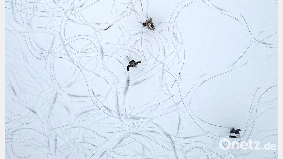 Muster im Schnee: Eine Luftaufnahme zeigt Schlittschuhläufer auf einem zugefrorenen See in Österreich. Bild: Helmut Fohringer/APA/dpa