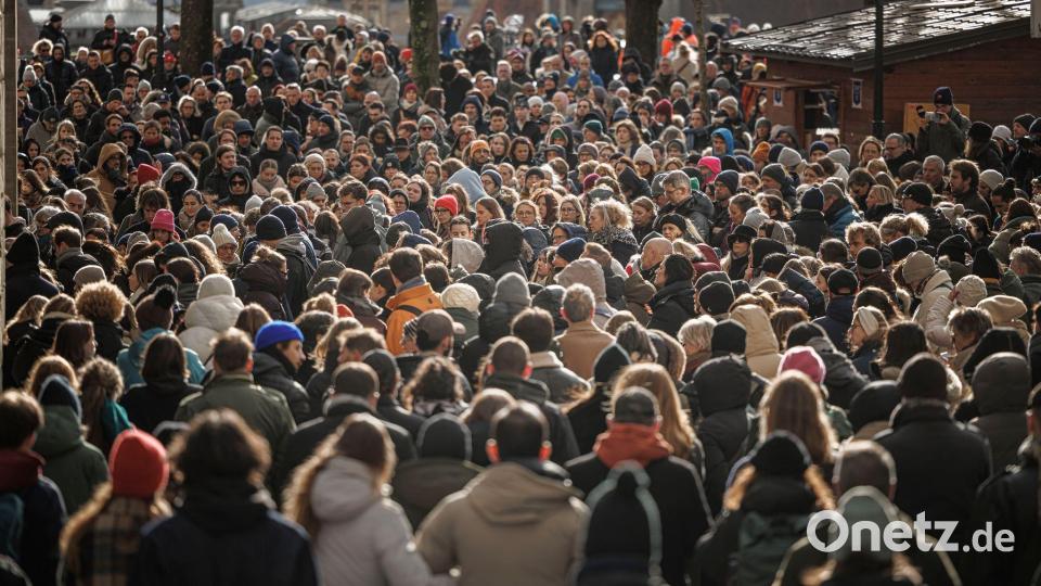 Menschen stehen zusammen während einer Schweigeminute bei der Trauerfeier für die Opfer des verheerenden Brandes in Crans-Montana in der Schweiz. Bild: Valentin Flauraud/KEYSTONE/dpa