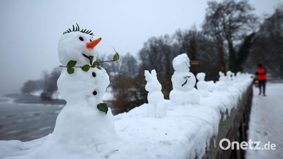 Eine ungewöhnliche Ausstellung: Zahlreiche kleine und winzige Schneefiguren stehen auf einer Mauer der Krugkoppelbrücke an der Alster im Hamburg. Bild: Christian Charisius/dpa