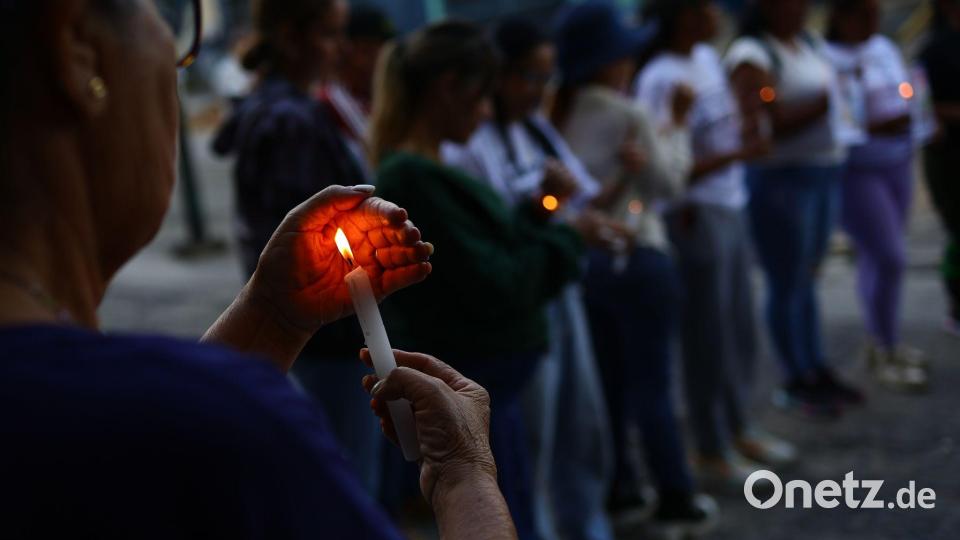 Eine Frau hält eine Kerze bei einer Demonstration für die Freilassung von politischen Gefangenen in der Nähe des Gefängnisses El Helicoide in Caracas. Bild: Javier Campos/dpa