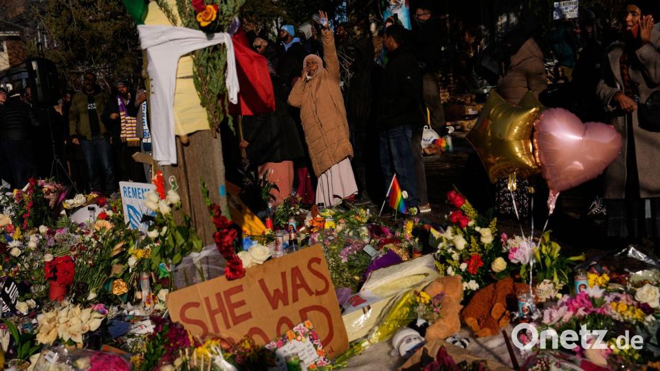 Menschen versammeln sich um eine provisorische Gedenkstätte zu Ehren der Frau, die von einem ICE-Beamten tödlich erschossen wurde. Bild: John Locher/AP/dpa