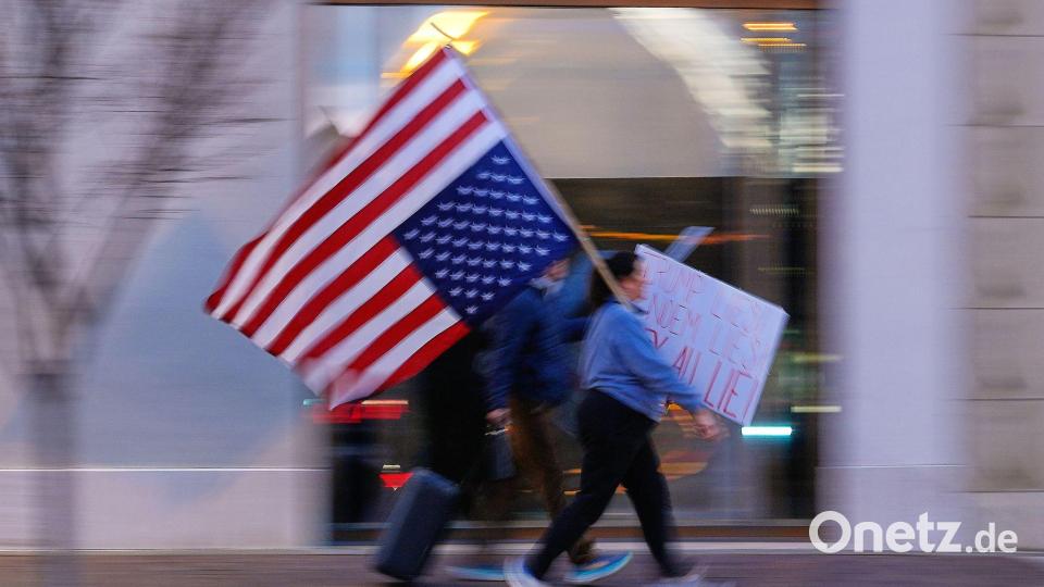 Nach ICE-Schüssen: Demonstrantub marschiert mit verkehrter US-Flagge durch Mall in Minneapolis Bild: Charlie Riedel/AP/dpa