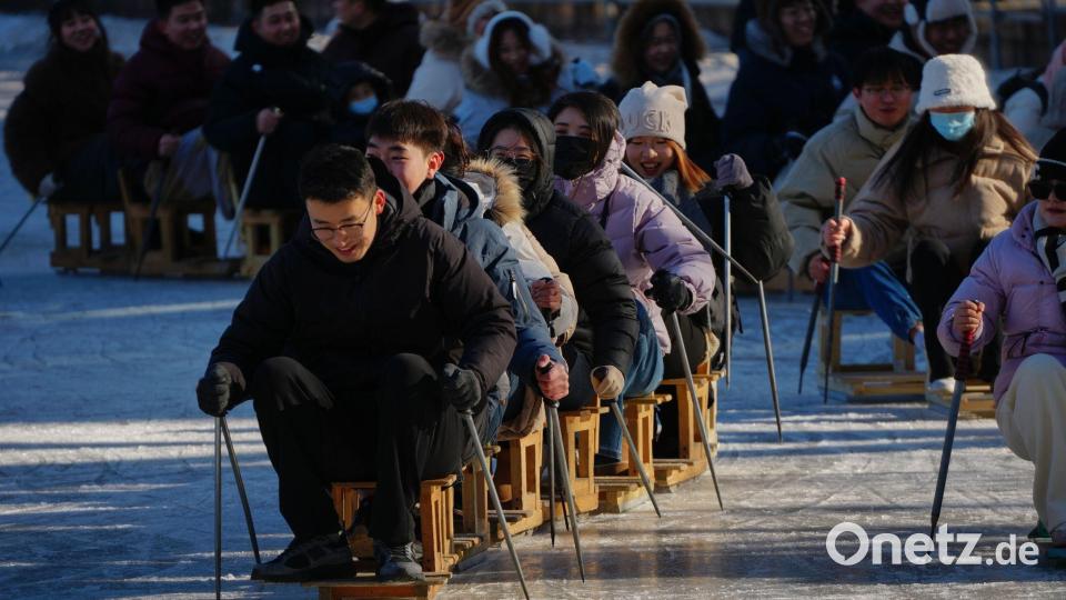 Wochenendspaß auf dem Eis: Stuhl-Skifahren im Park von Peking Bild: Andy Wong/AP/dpa