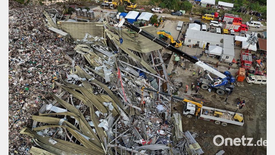 Die Einsatzkräfte suchen unter anderem mit einem Kran in den Abfall-Massen. Bild: Jacqueline Hernandez/AP/dpa