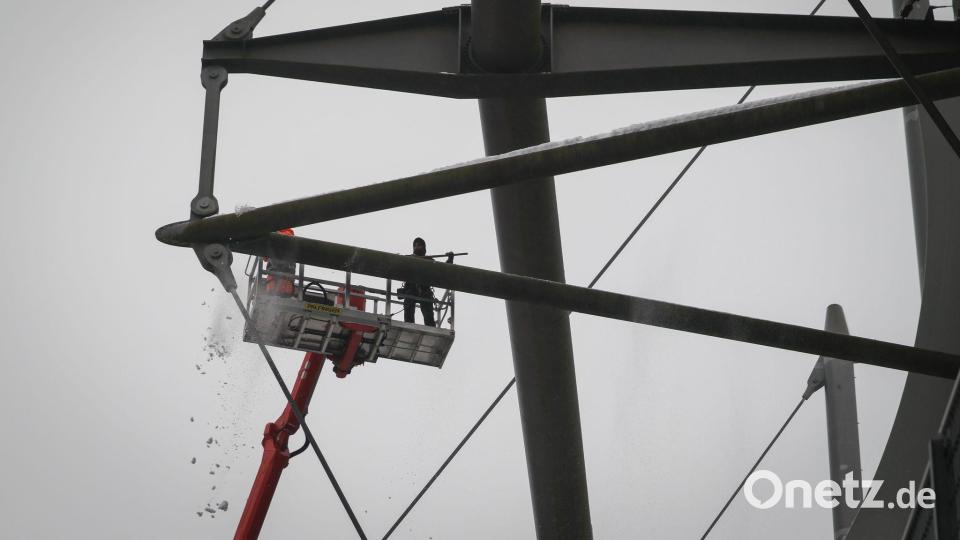 Arbeiter mit einem Hubsteiger entfernen Eis und Schnee von den Trägern des Stadiondachs am Volksparkstadion. Bild: Christian Charisius/dpa
