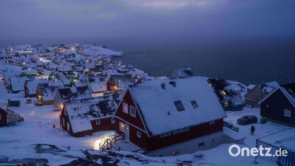 Schnee bedeckte Häuser stehen an der Küste einer Meeresbucht in Nuuk, der Hauptstadt von Grönland. Bild: Evgeniy Maloletka/AP/dpa