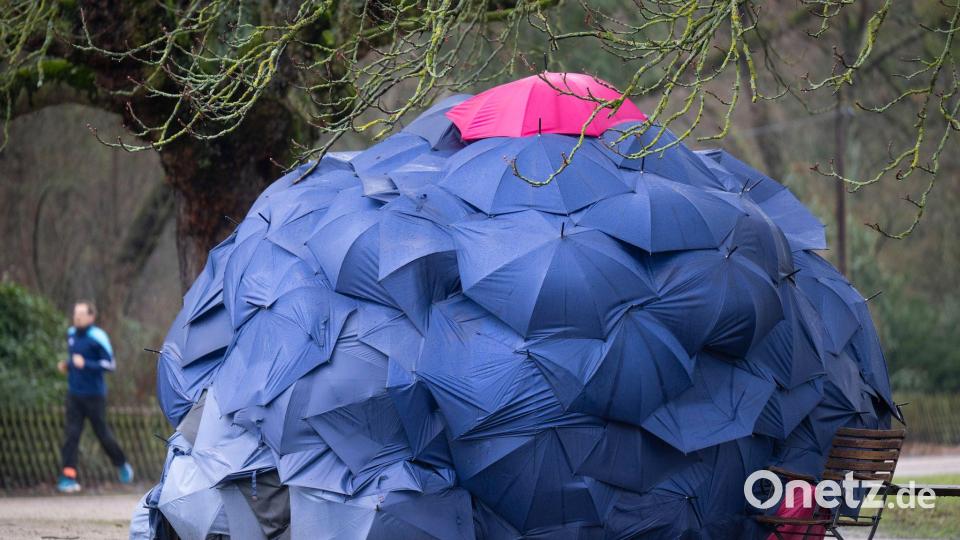 Eine Konstruktion aus Schirmen: Eine Frau hat sich bei einstelligen Temperaturen eine provisorische Bleibe in einem Park gebaut. Bild: Boris Roessler/dpa