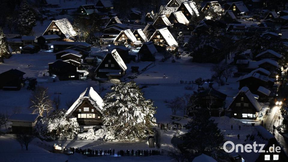 Traditionelle Strohdachhäuser sind mit Schnee bedeckt und werden im zum Weltkulturerbe gehörenden Dorf Shirakawa-go in der Präfektur Gifu in Zentraljapan beleuchtet. Bild: Uncredited/kyodo/dpa