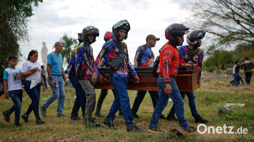 Mitglieder eines Motorradclubs und Freunde tragen den Sarg eines venezolanischen Polizisten. Bild: Ariana Cubillos/AP/dpa