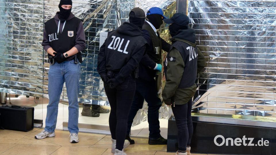 Zollbeamte stehen vor einem Nagelstudio in der Neumarktgalerie in der Innenstadt von Köln. Bild: Henning Kaiser/dpa