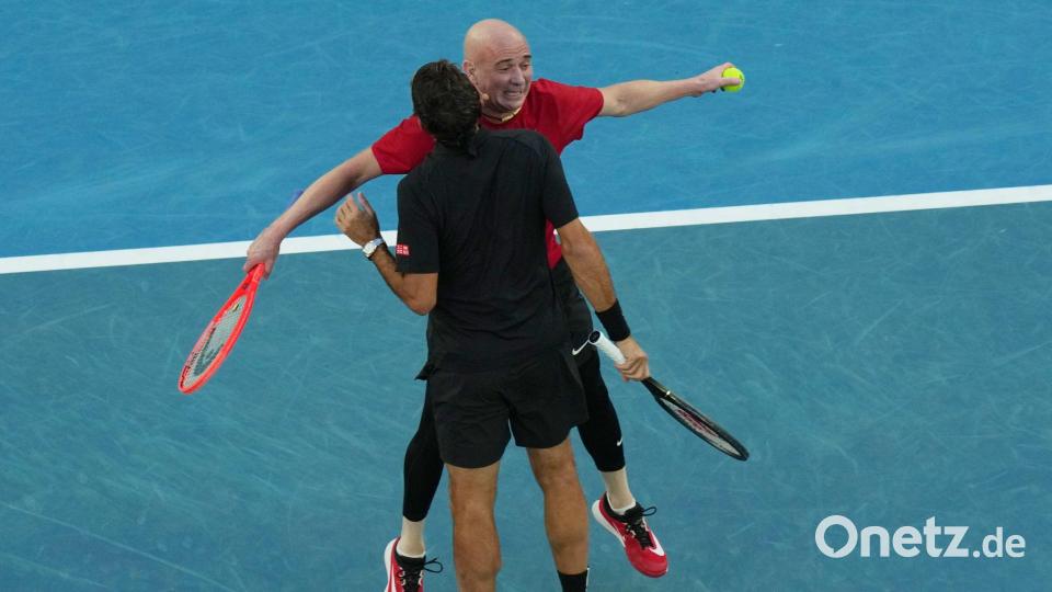 Australian Open - Eröffnungszeremonie: Roger Federer (vorne) aus der Schweiz und Andre Agassi aus den USA reagieren während der Eröffnungsfeier auf ihr Doppelspiel gegen Hewitt und Rafter aus Australien. Bild: Dar Yasin/AP/dpa