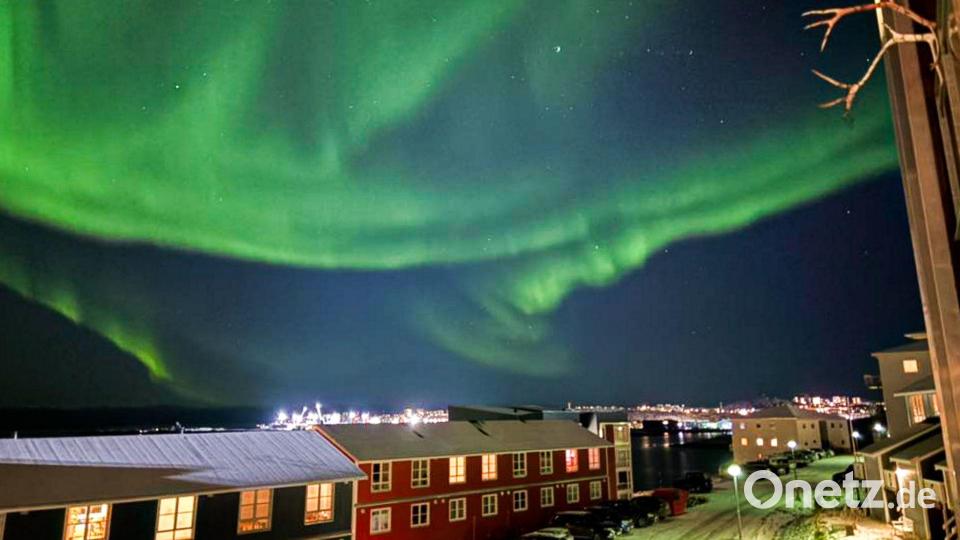 Grün leuchtende Nordlichter bedecken den Himmel über der Stadt Nuuk. Bild: Alyona Kekhler/TASS via ZUMA Press/dpa