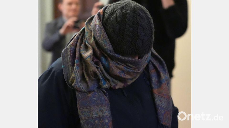 Eine Zeugin verlässt vermummt den Gerichtssaal. Bild: Marcus Brandt/dpa