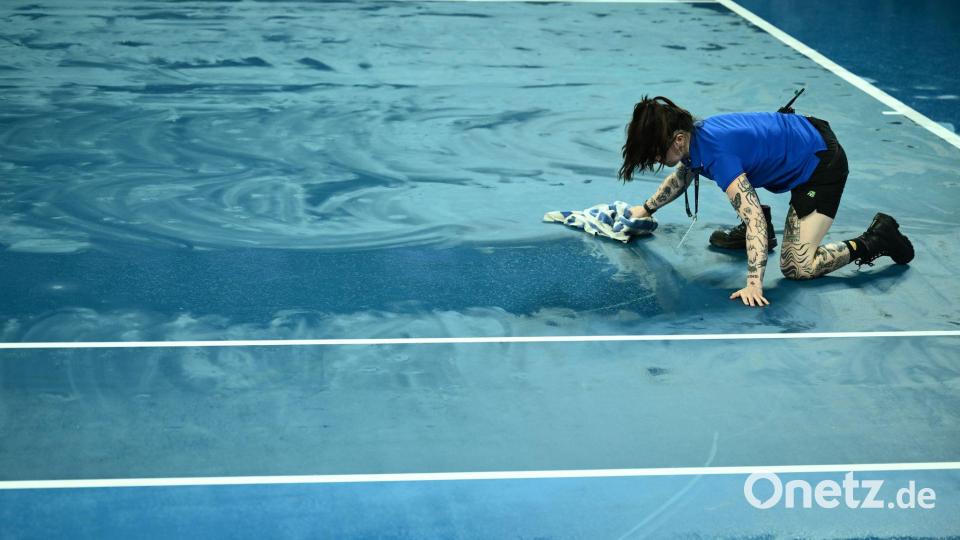 Ballkinder versuchten mit Handtüchern, die Plätze im Melbourne Park wieder zu trocknen. Bild: Joel Carrett/AAP/dpa