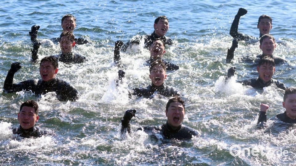 Bei Minusgraden singen Taucher der südkoreanischen Marine, während sie im eiskalten Meerwasser vor der Stadt Changwon schwimmen. Bild: yonhap/dpa