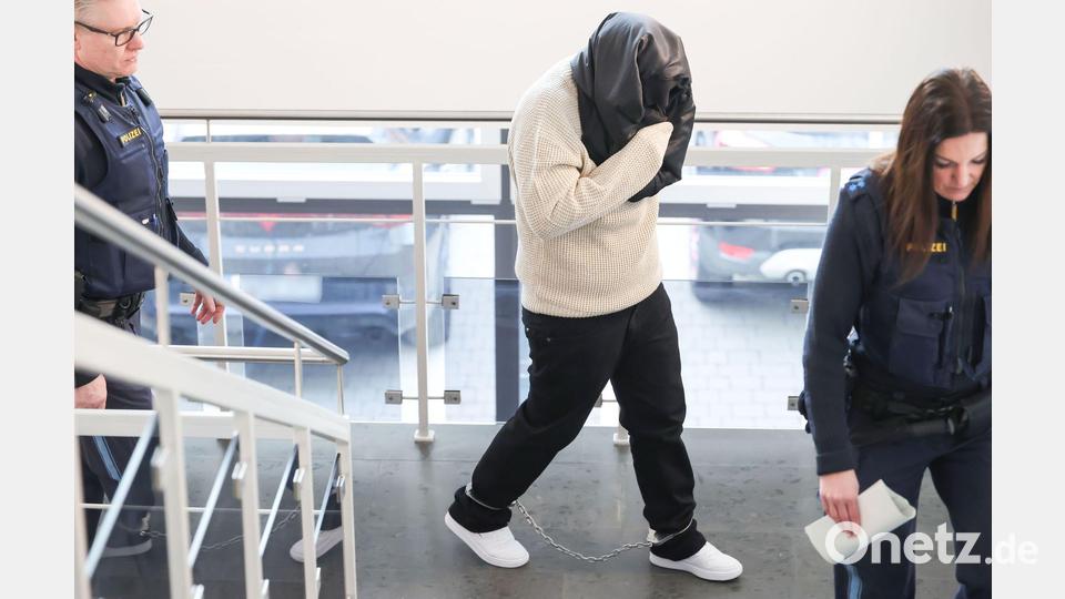 Die Angeklagte hat sich eine Jacke um den Kopf gewickelt, um ihr Gesicht vor den Kameras zu verbergen. Bild: Daniel Löb/dpa