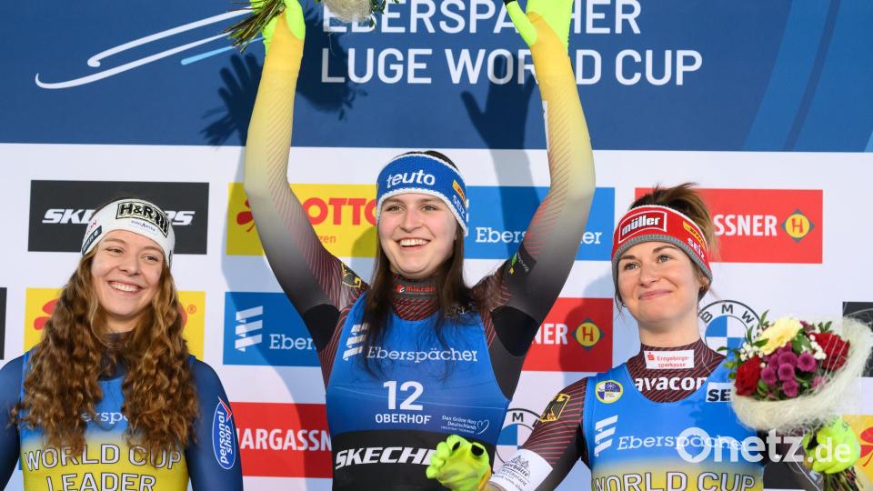 Siegerin Merle Fräbel (Deutschland, M), die Zweitplatzierte Lisa Schulte (Österreich, l) und die Drittplatzierte Julia Taubitz (Deutschland) stehen in Oberhof auf dem Podium. Bild: Robert Michael/dpa