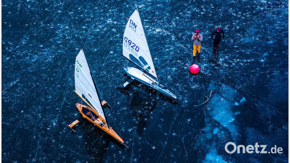 Eissegler bereiten ihre Schlitten auf der mit einer etwa 15 Zentimeter dicken Eisschicht bedeckten Kleinen Müritz für einen Testfahrt vor (Luftaufnahme mit einer Drohne). Bild: Jens Büttner/dpa