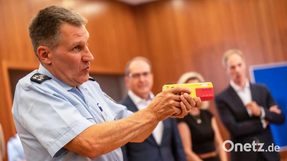 Ein Polizist erklärte die Funktionsweise eines Distanz-Elektroimpulsgeräts im vergangenen Jahr im Innnenministerium. (Archivfoto) Bild: Michael Kappeler/dpa