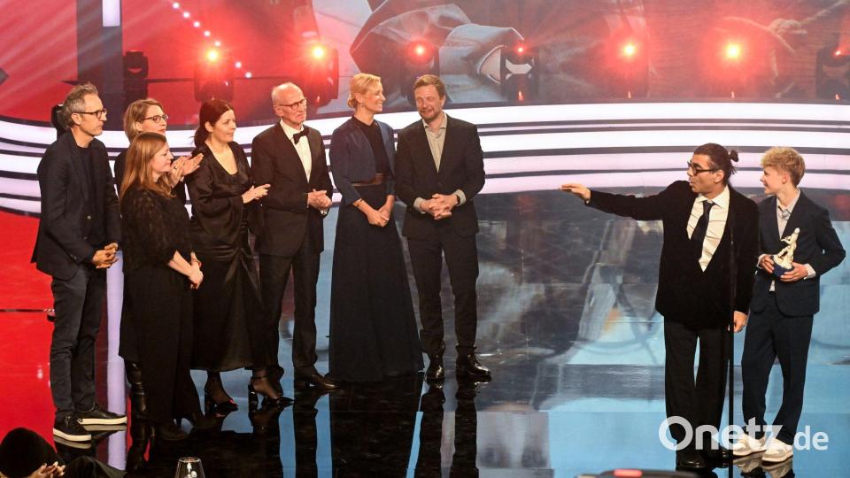 Regisseur Fatih Akin, Schauspieler Jasper Billerbeck mit dem Team der Produktionsfirma bombero international stehen auf der Bühne. Ihr Film „Amrum“ wurde als Bester Film ausgezeichnet. Bild: Felix Hörhager/dpa