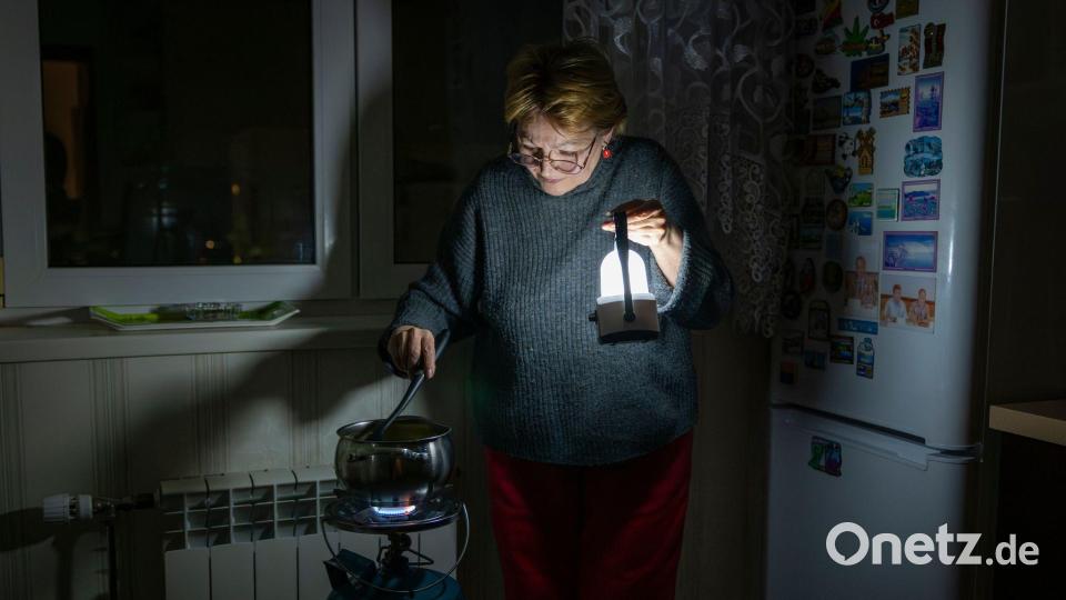 Eine Mutter kocht auf einem Gasbrenner nach einem Stromausfall in Kiew durch einen russischen Angriff. Bild: Dan Bashakov/AP/dpa