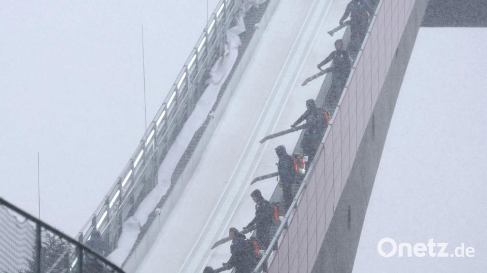 Zu viel des Guten: Mitarbeiter blasen beim Probedurchgang zur WM im Teamfliegen in Oberstdorf Schnee von der Flugschanze. Bild: Karl-Josef Hildenbrand/dpa
