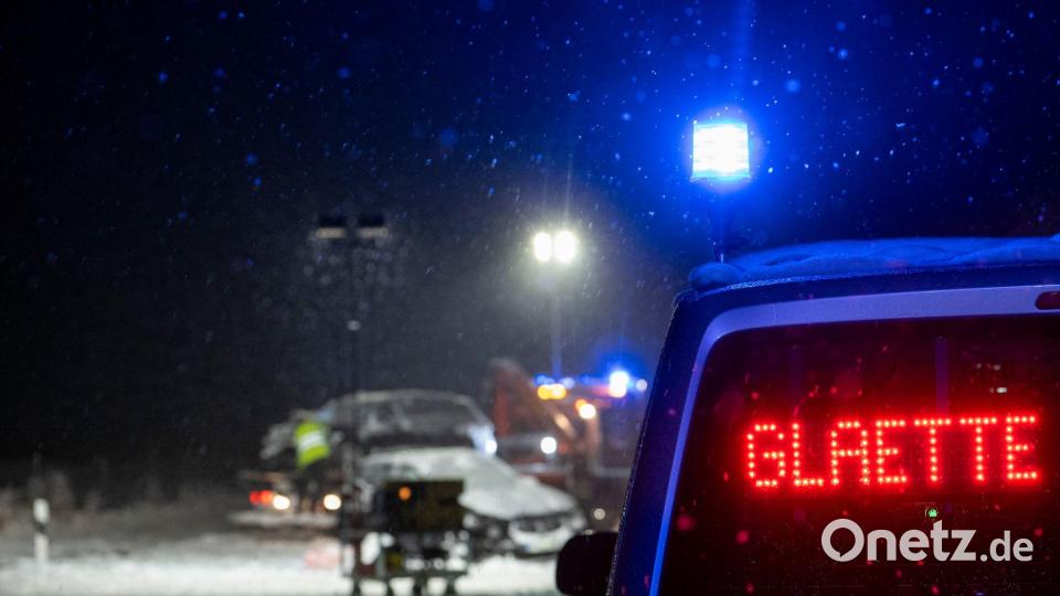 Auf der verschneiten Bundesstraße 12 warnt an einer Unfallstelle ein Polizeifahrzeug vor Glätte. Bild: Stefan Puchner/dpa